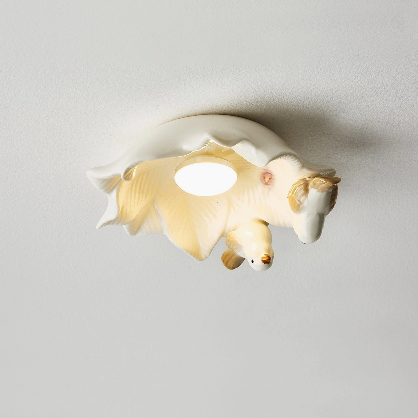 Magnolia Nest ceiling light with single ceramic bird in view and warm glowing light effect artistic design detail