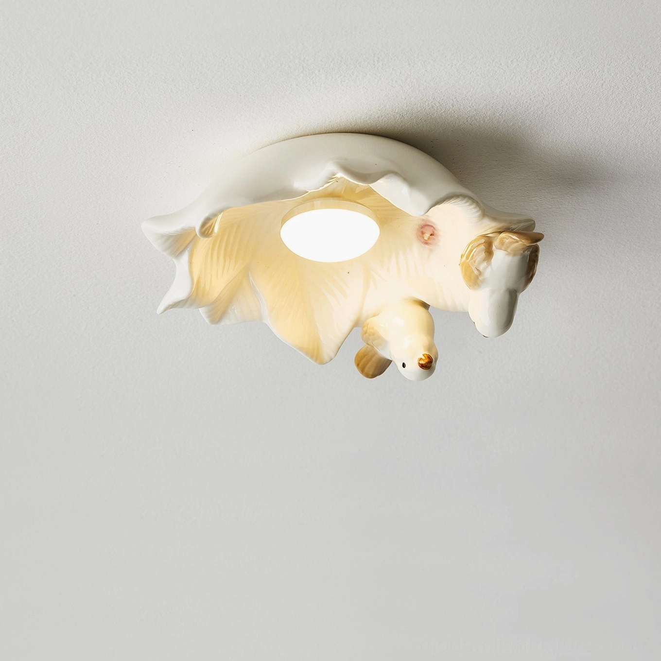 Angled overhead view of Magnolia Nest bird ceiling light with cream ceramic finish and warm central illumination