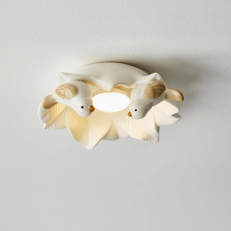 Side overhead view of Magnolia Nest modern ceiling lamp with warm illuminated center and artistic ceramic bird details