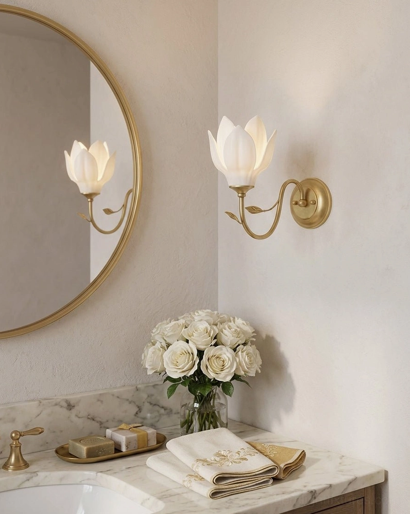 Pair of magnolia bud wall sconces flanking bathroom vanity mirror with marble countertop and floral decor