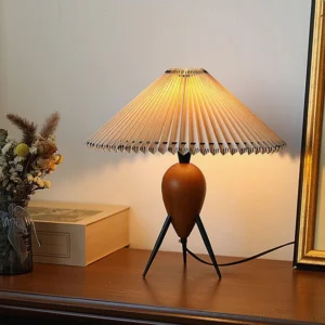 Makie wooden base table lamp lit on retro dresser with warm ambient lighting and vintage decor
