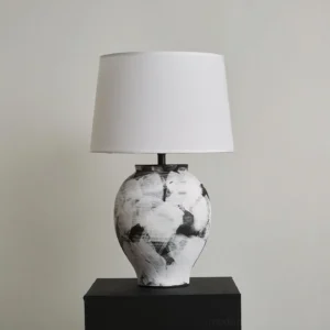 Modern Malta table lamp featuring urn-shaped hand-painted ceramic base displayed on black pedestal unlit