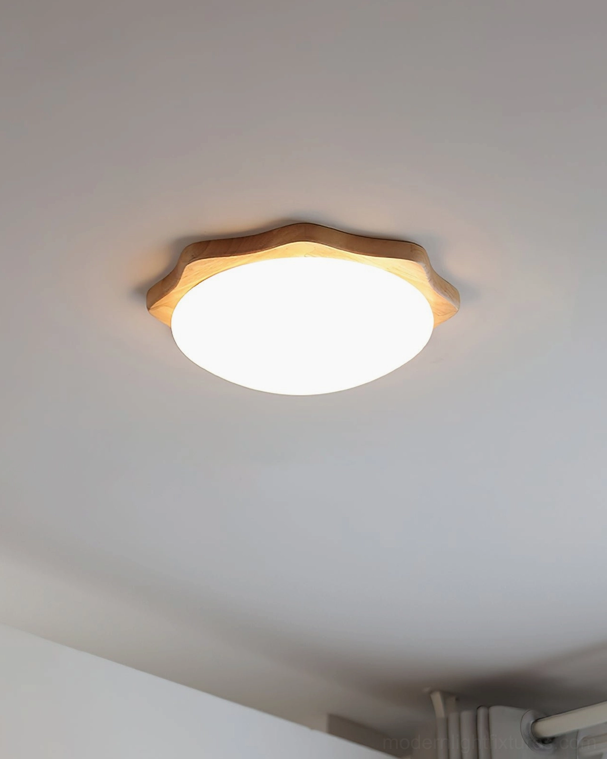 Natural maple wood ceiling light mounted overhead, low-angle eye-level view showing wavy wooden frame and round light panel detail