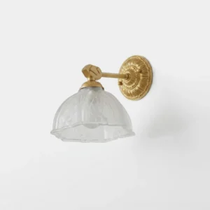 Marceau frosted glass dome wall sconce with brass backplate and arm, front studio view showing embossed glass shade detail