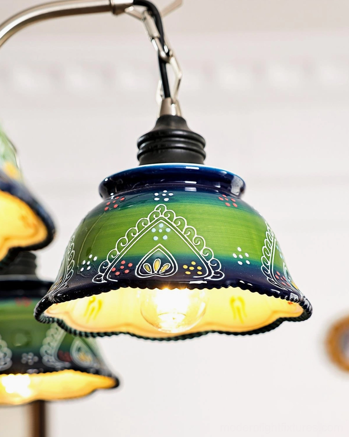 Close-up macro detail of Marcella green ceramic lamp shade with folk-inspired patterns, gradient effect, and scalloped rim