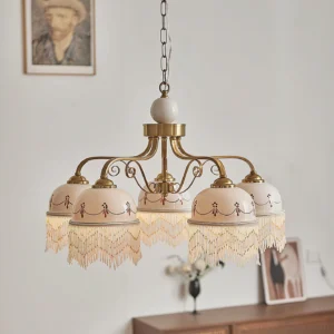 5-head Marcelline vintage chandelier in retro living room setting, brass gold frame with embroidered off-white shades and cascading beaded trim