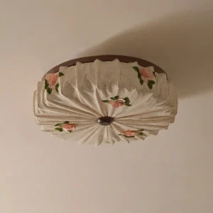 Close-up detail of Maribelle flush mount showing radial pleated linen fabric and molded rose flowers with dark painted alloy rim