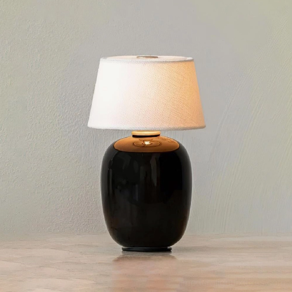 Glossy black ceramic table lamp with brass accent trim – minimalist Nordic design front product shot