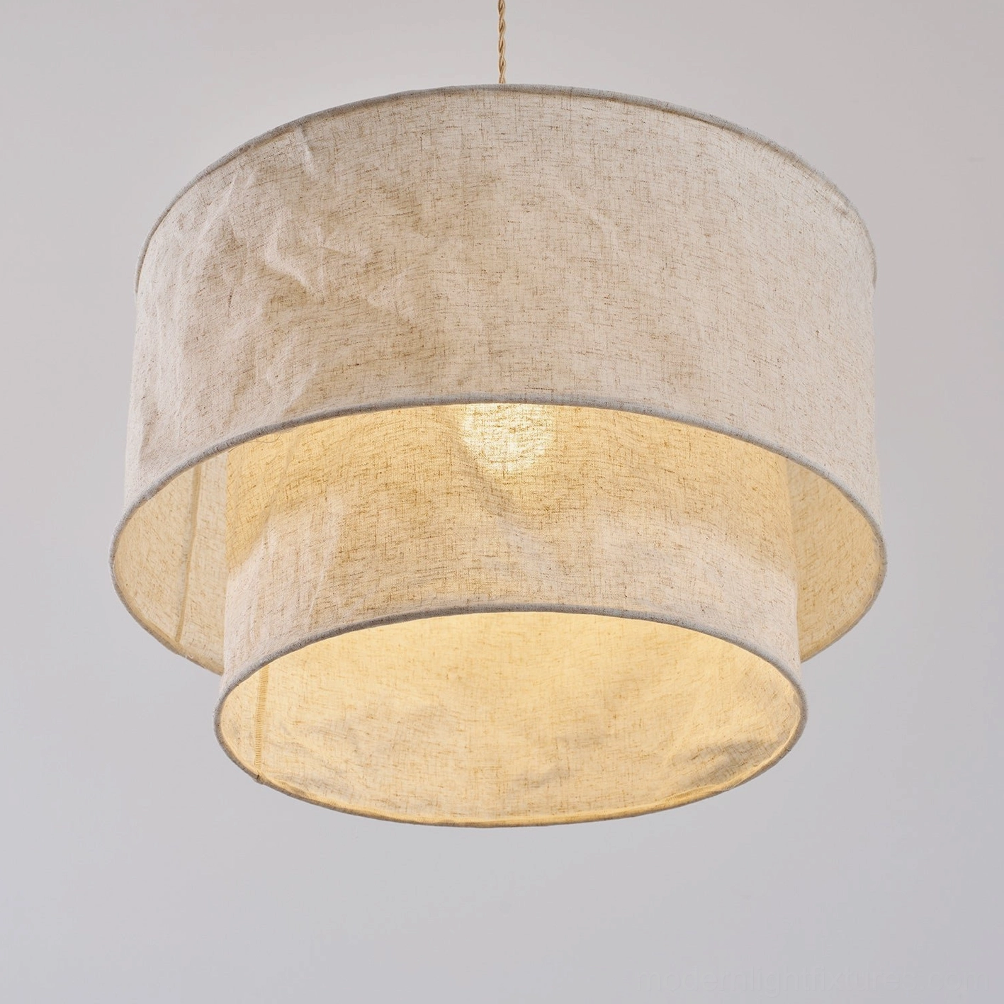 Double-layer fabric pendant light fixture suspended in contemporary interior with warm glow