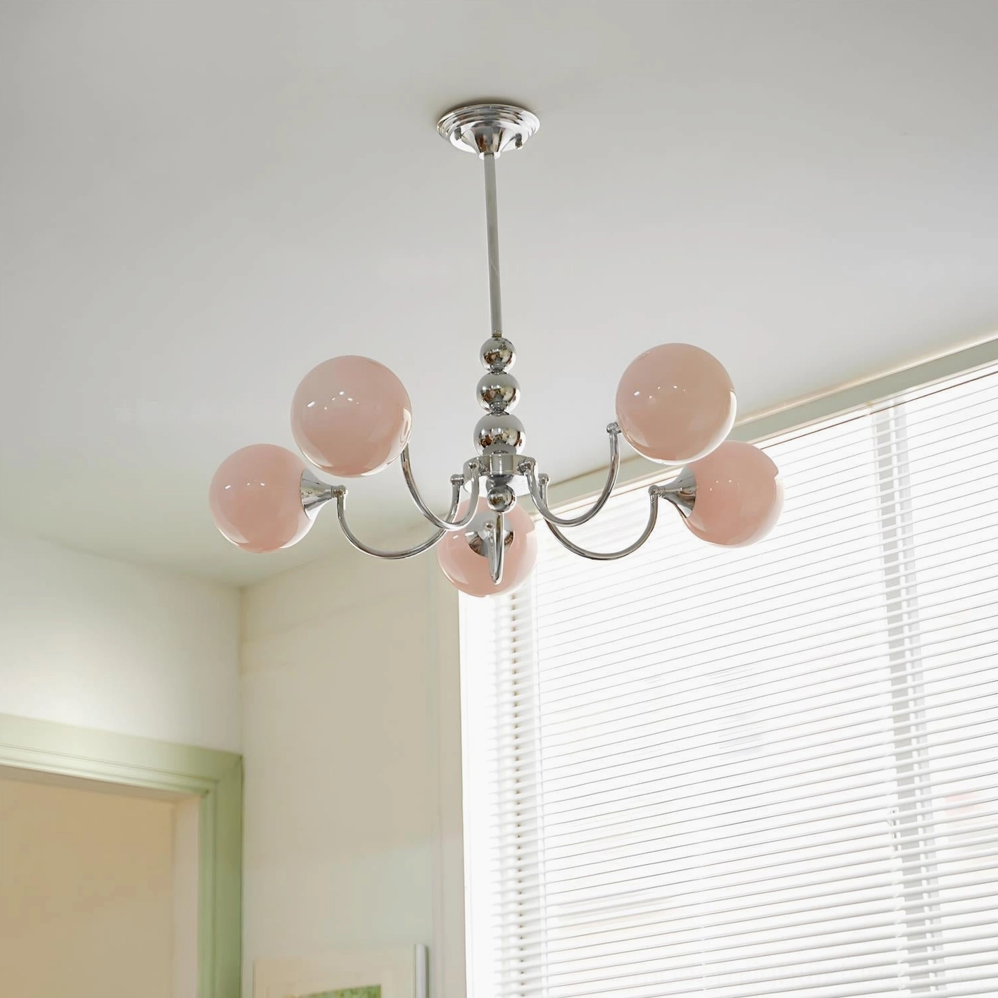 Pink globe mid-century modern chandelier with smooth sculptural silhouette and glossy finish reflection