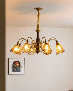 Marigold amber glass chandelier glowing warm light in residential interior, lit bulbs illuminating vintage brass and wood accents