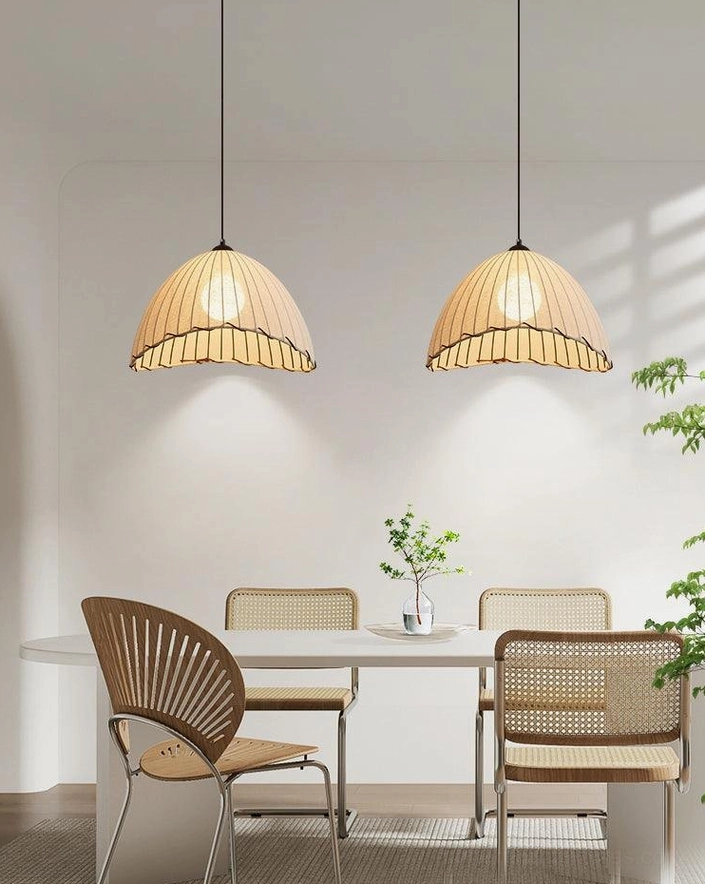 Pair of matching pleated fabric pendant lights creating warm ambiance in minimalist dining room