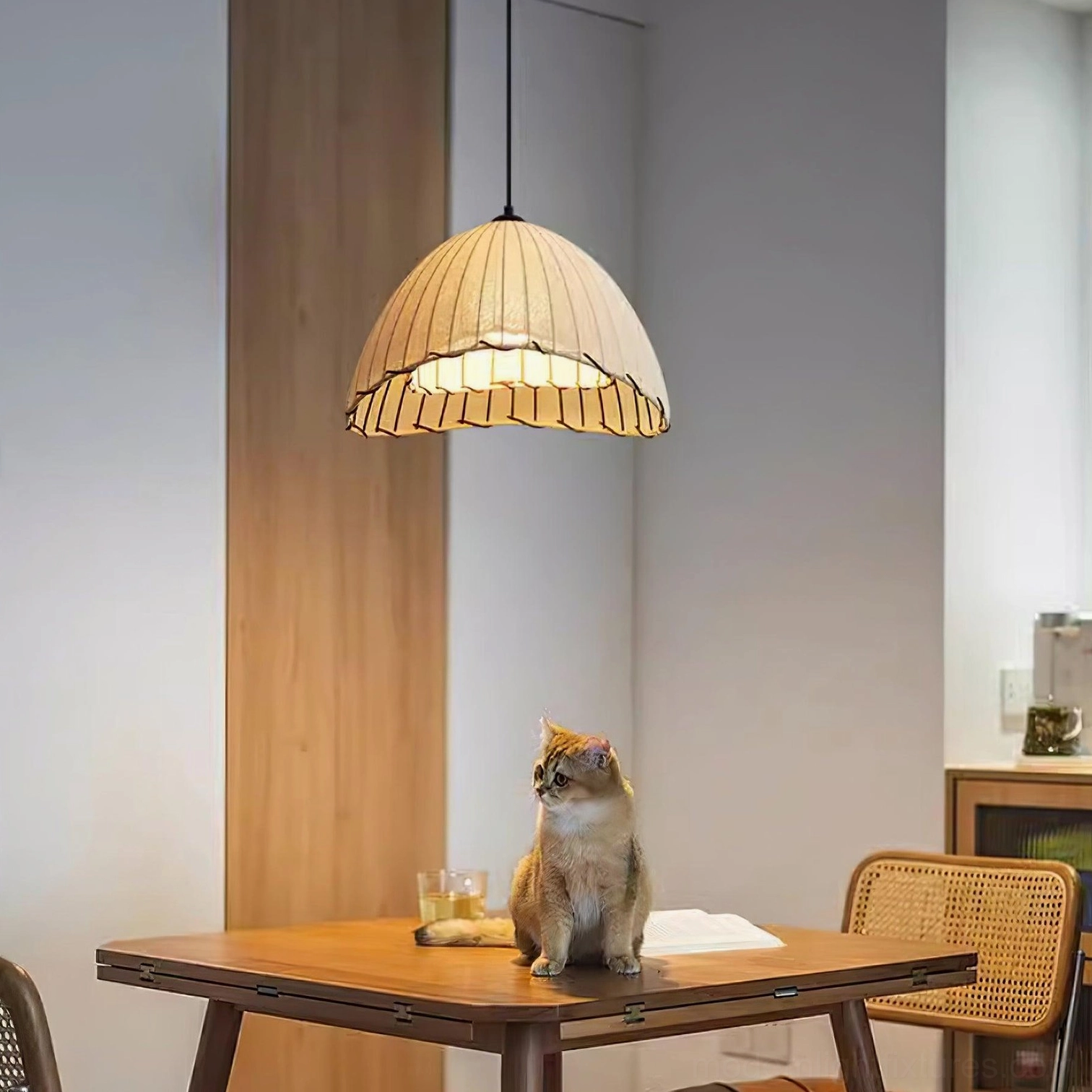 Modern pleated pendant lamp with ribbed linen shade installed in warm residential dining space
