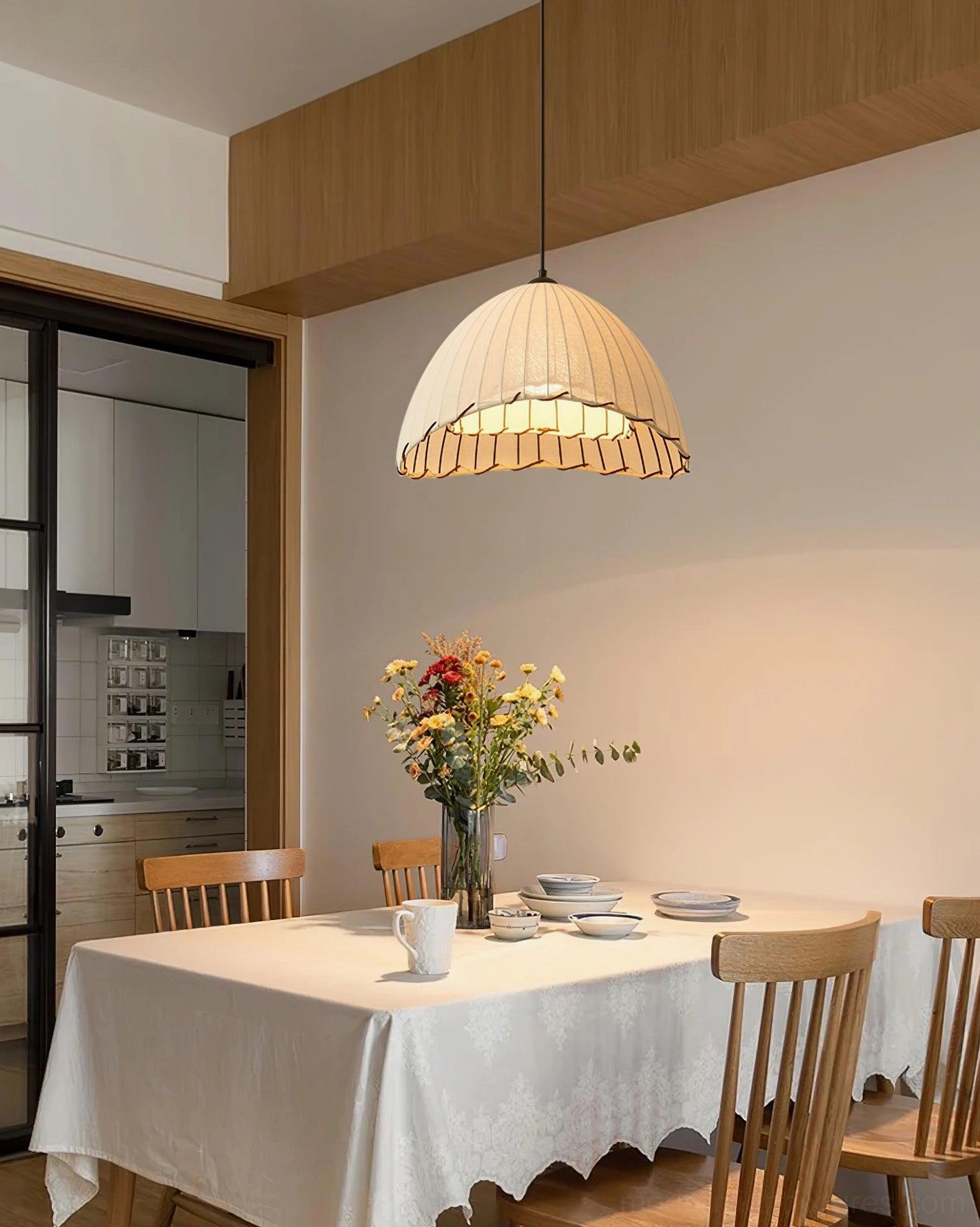 Modern fabric pendant lamp with scalloped linen shade in formal dining room with open kitchen