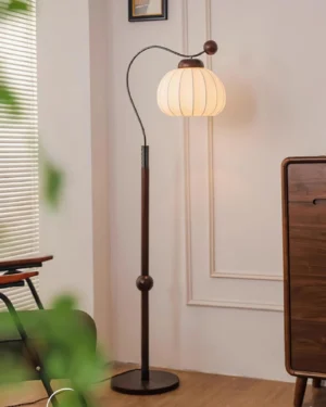 Mid-century modern arc floor lamp with illuminated fabric shade in vintage living room setting