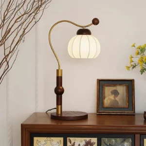 Vintage-style Marisa table lamp displayed on side table in retro home interior with framed artwork and botanical decor, demonstrating warm ambient lighting