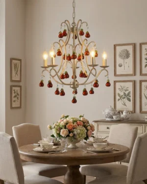 Five-arm candle chandelier with amber glass fruit drops hanging over round dining table in French country dining room