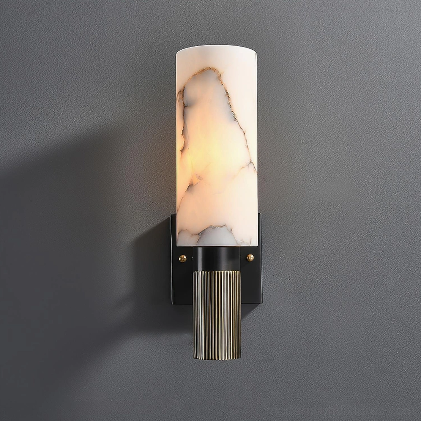 Three-quarter view of alabaster wall lamp with black brass base and ribbed bronze detail