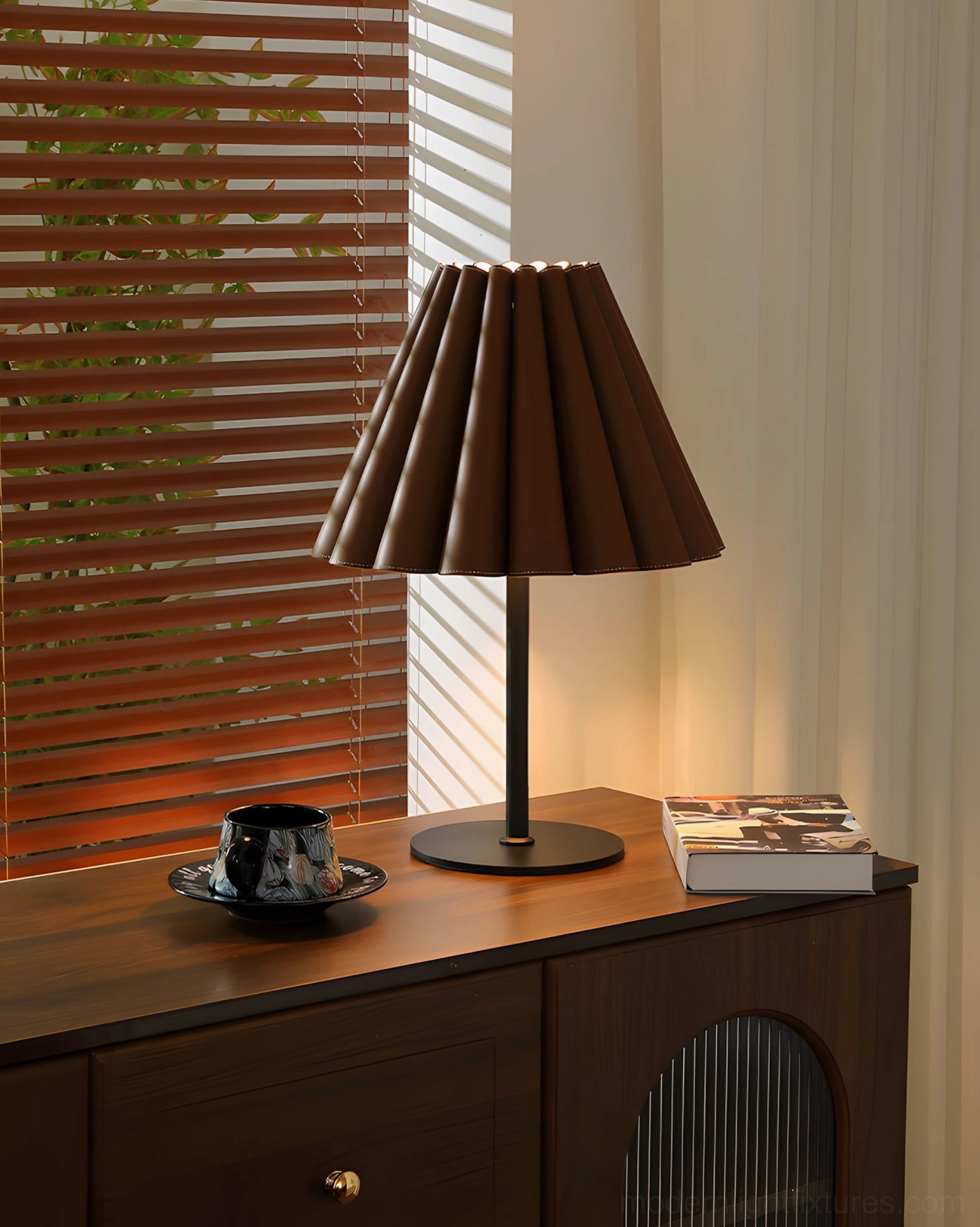 Marlow mid-century modern pleated leather table lamp on console table by window with wooden blinds and natural light