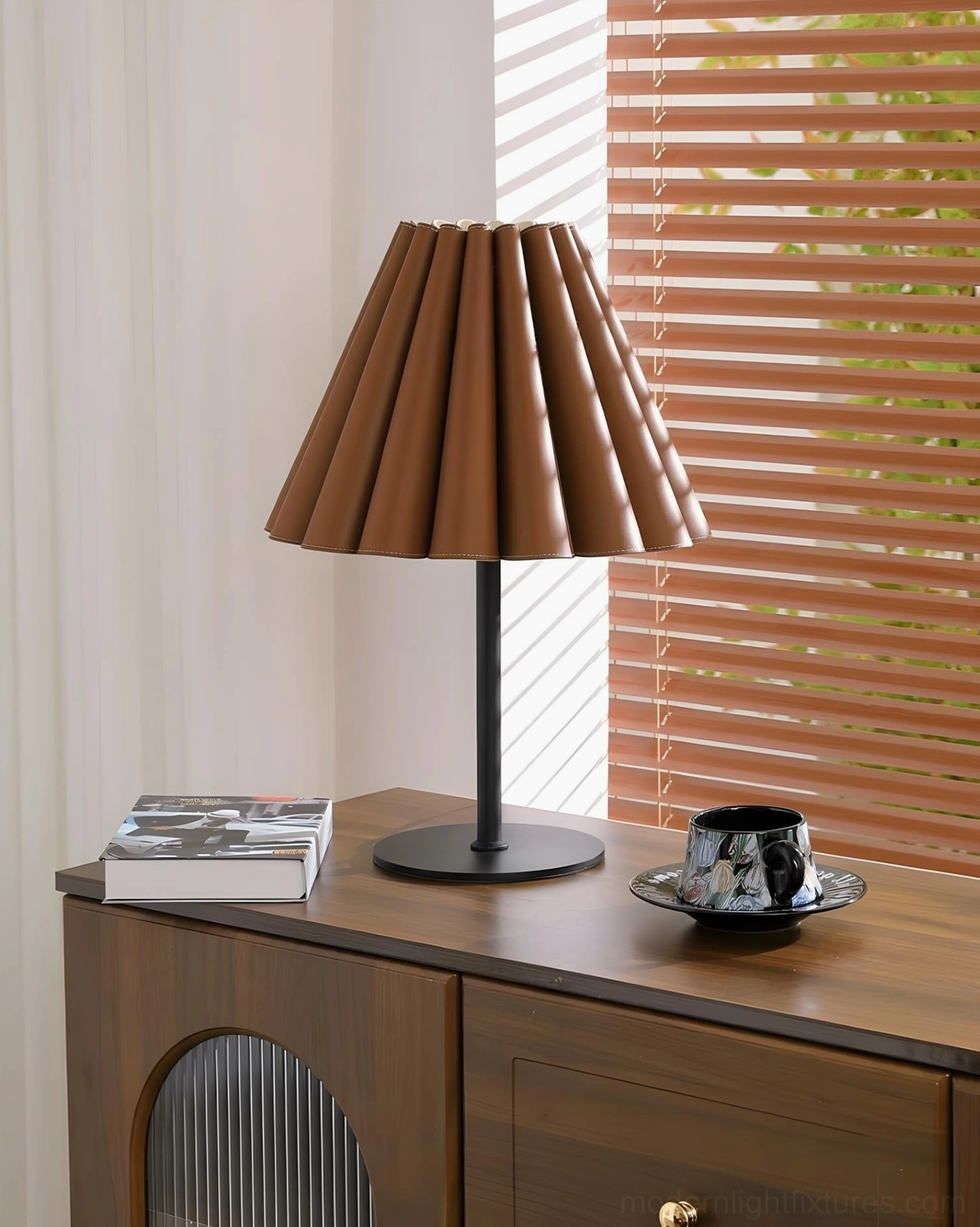 Marlow pleated leather table lamp side three-quarter view on wooden cabinet with soft natural light and reading setup