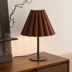 Marlow leather accordion pleated table lamp three-quarter view on vintage wooden side table with decorative plant
