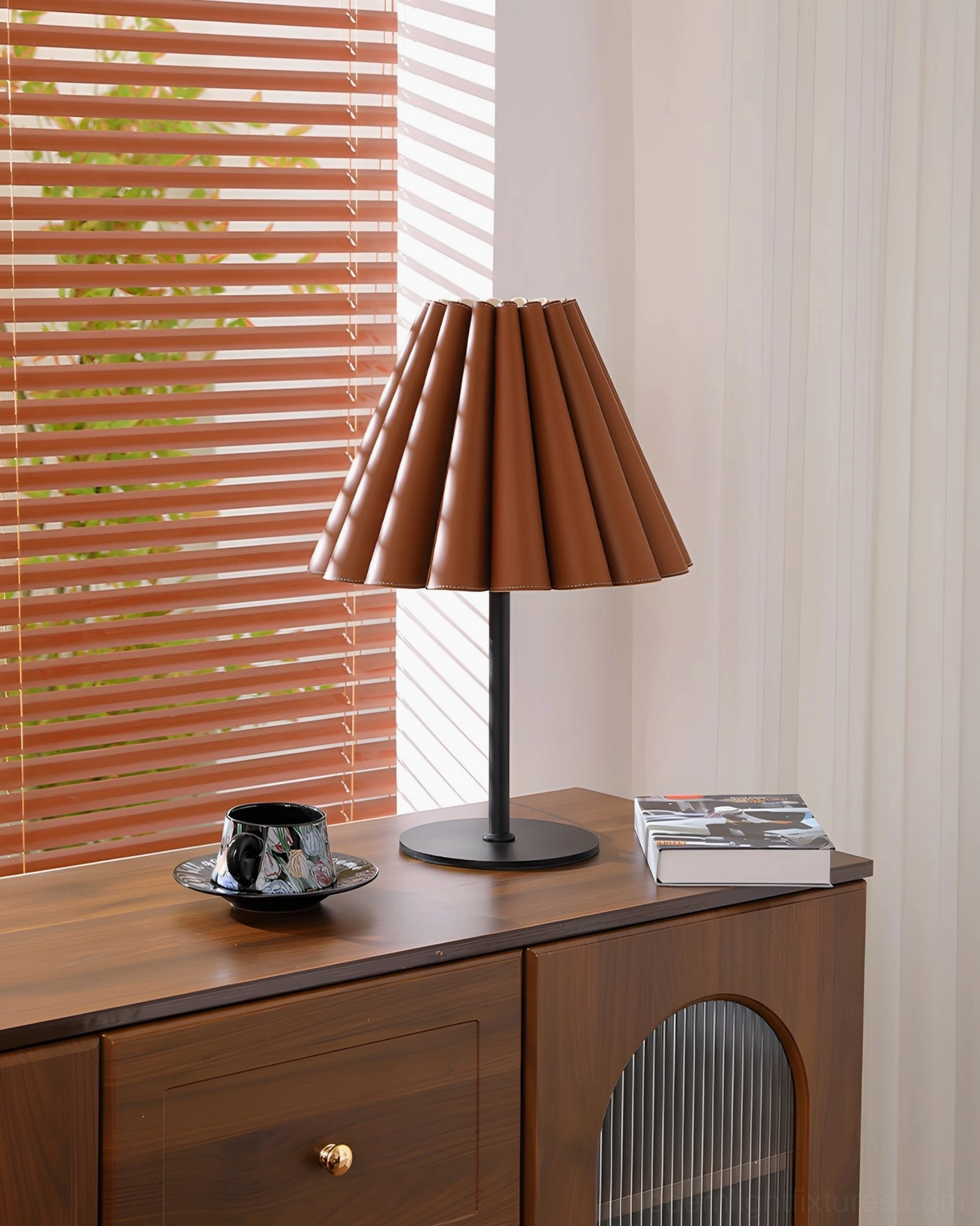 Marlow leather table lamp front three-quarter view showing pleated shade detail on wooden side cabinet with book and coffee