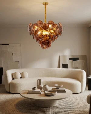 Tiered glass disc chandelier in modern minimalist living room with warm beige interior and curved sofa