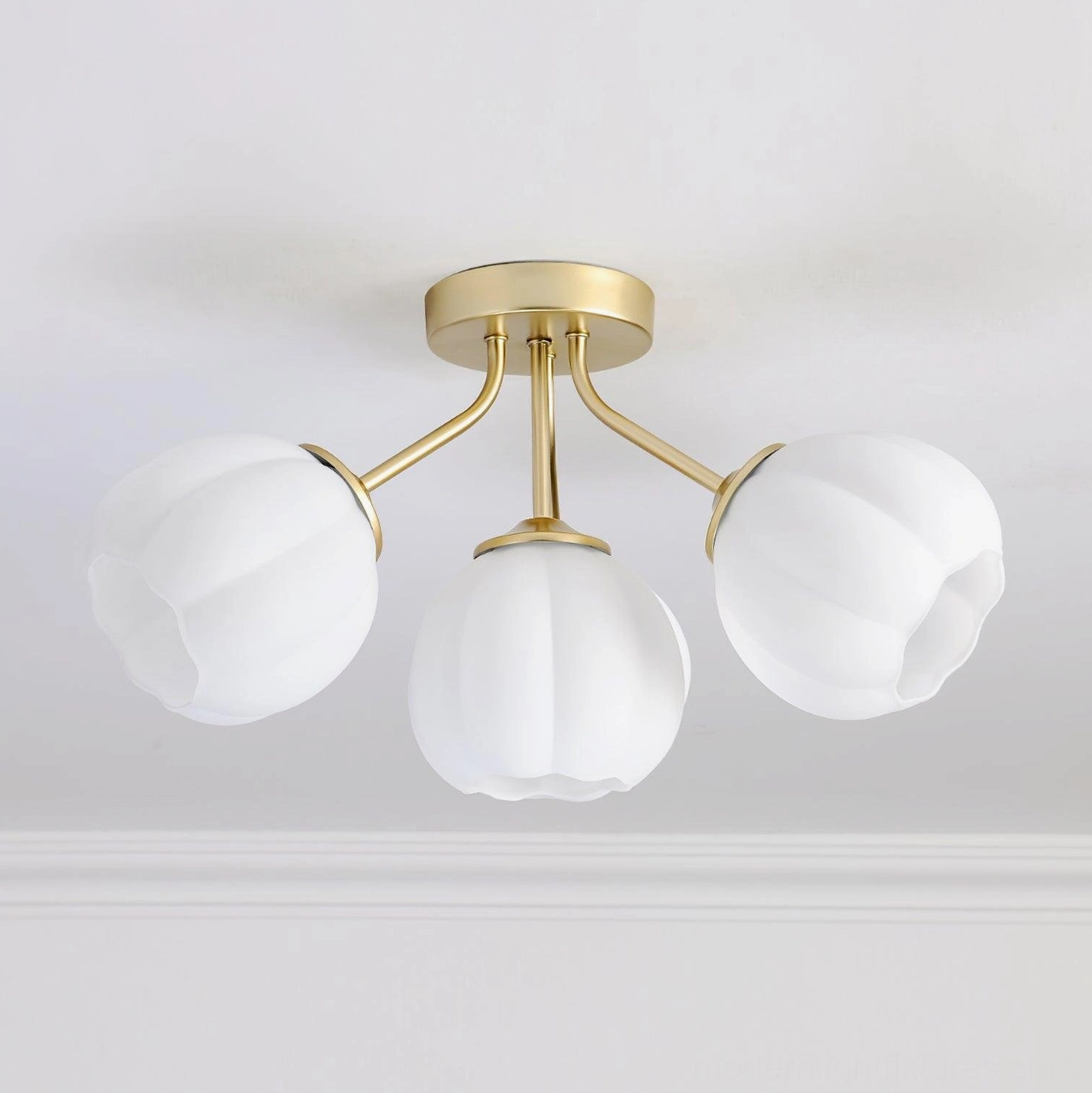 3-head Marra floral ceiling light with simplified brushed gold frame and smooth rounded frosted glass shades on white ceiling