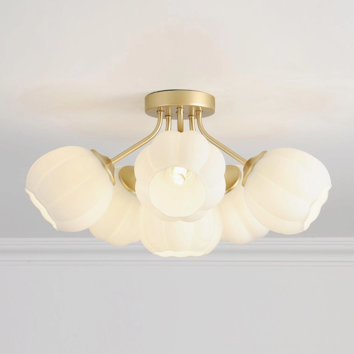 Overhead view of 6-head Marra ceiling light fixture showing brushed gold fixtures and frosted white rounded glass shades