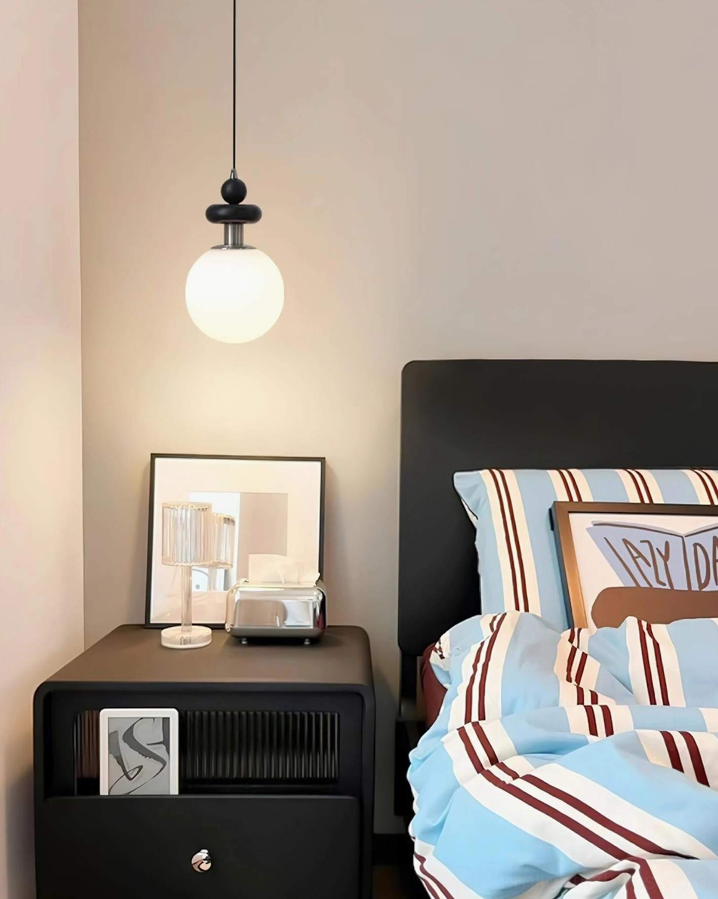 Marra Globe Pendant Light hanging above bedroom bedside area, coordinating with contemporary bedroom decor and lighting design
