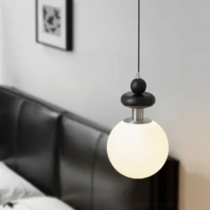 Marra Globe Pendant Light hanging in contemporary living room above black leather sofa, showing side view and ambient lighting effect