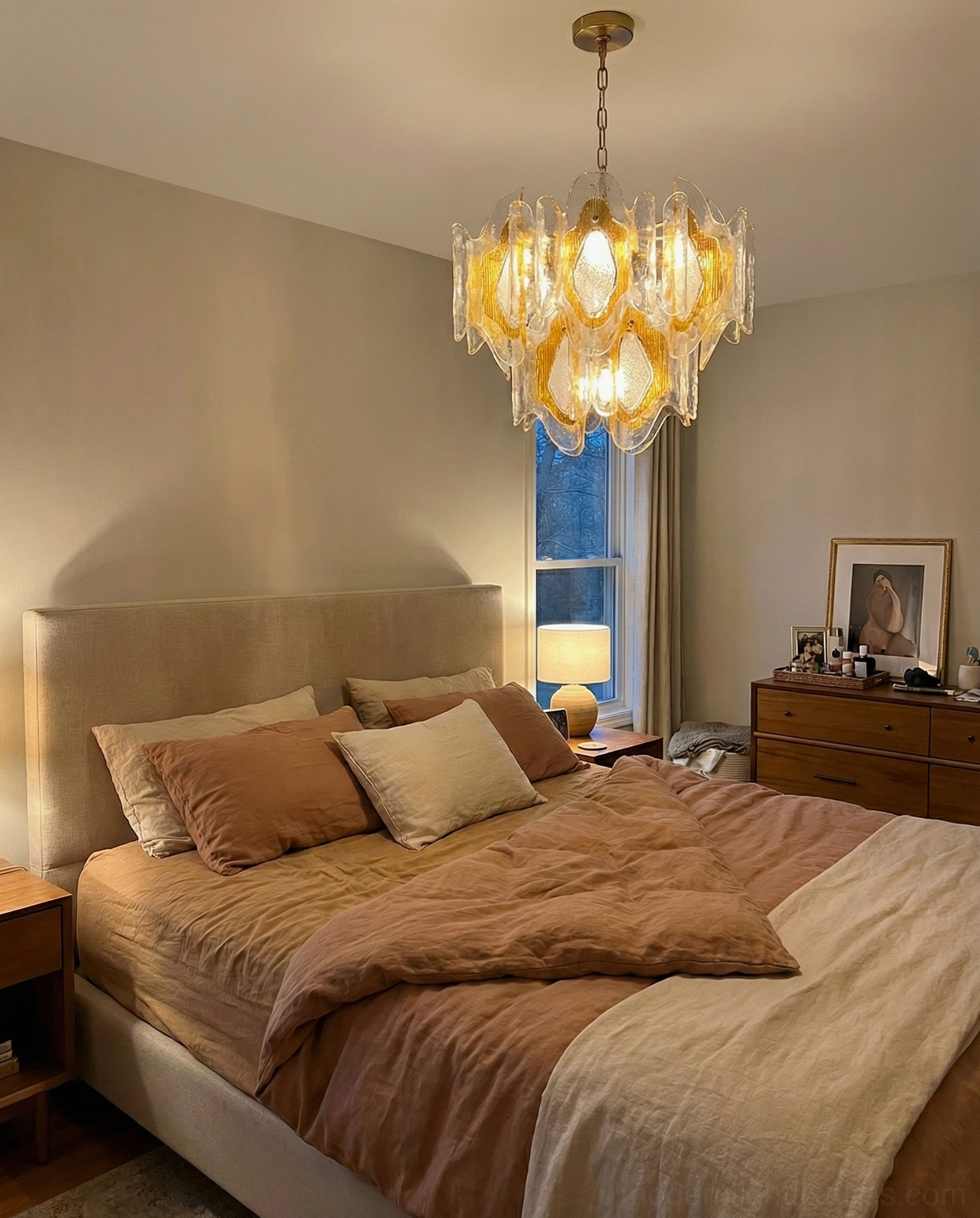 Vintage amber hand-blown glass chandelier in master bedroom above bed with warm lighting