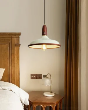 Single pendant light hanging in modern bedroom interior with warm glow, nightstand and wooden bed frame