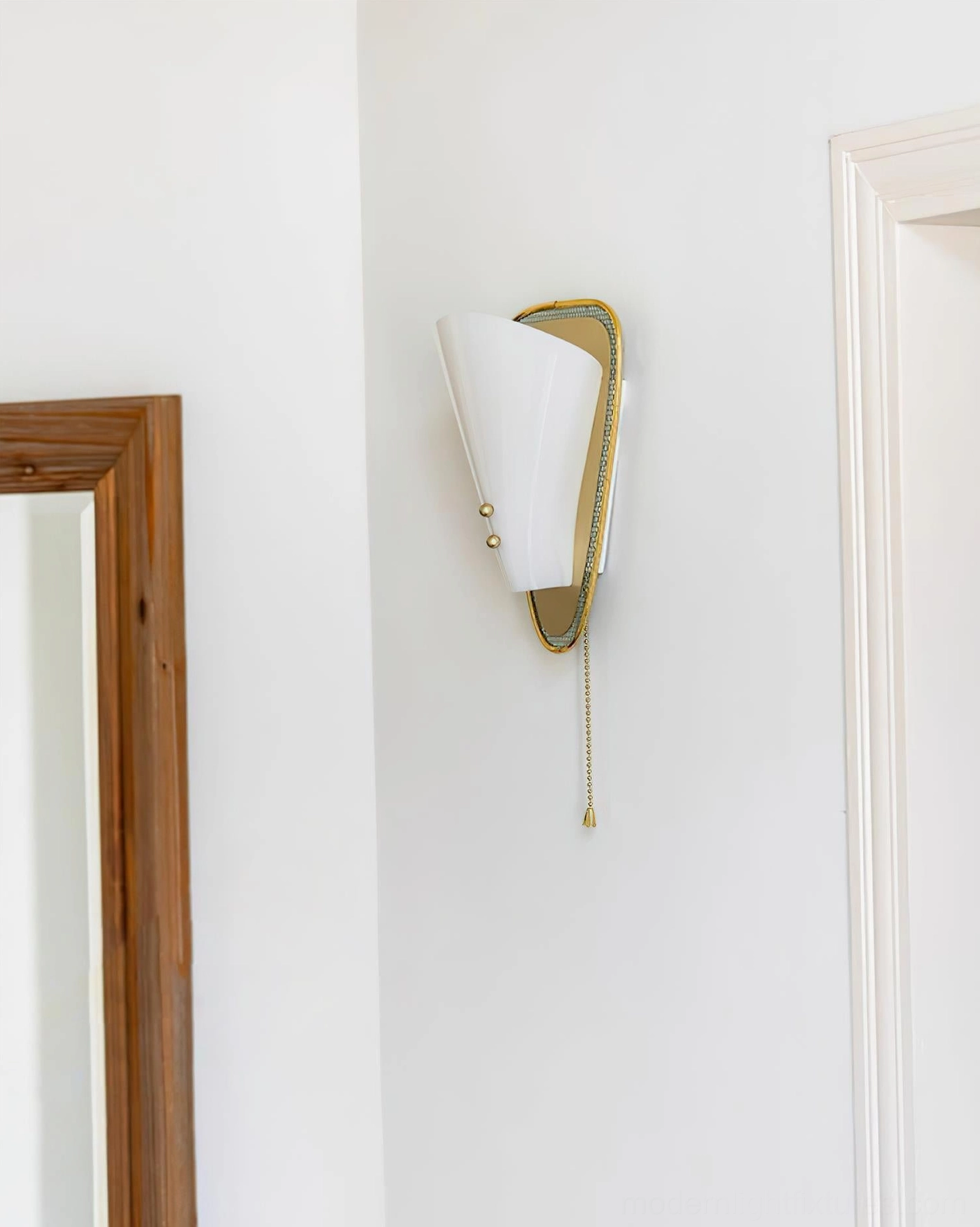 Marzio mid-century modern wall sconce mounted on residential wall with mirror and doorway showing compact profile
