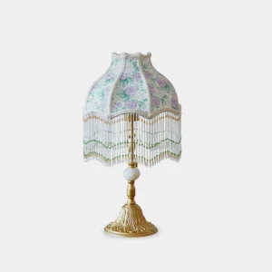 Masa floral table lamp front view with purple fabric shade, brass gold base, and beaded fringe details on white background