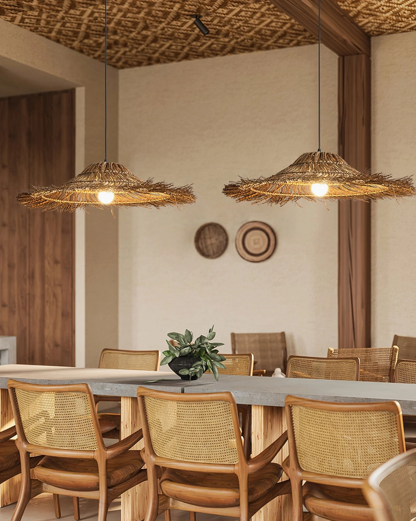 Dual matching rattan pendant lamps hanging over wooden dining table in rustic bohemian formal dining room with warm lighting