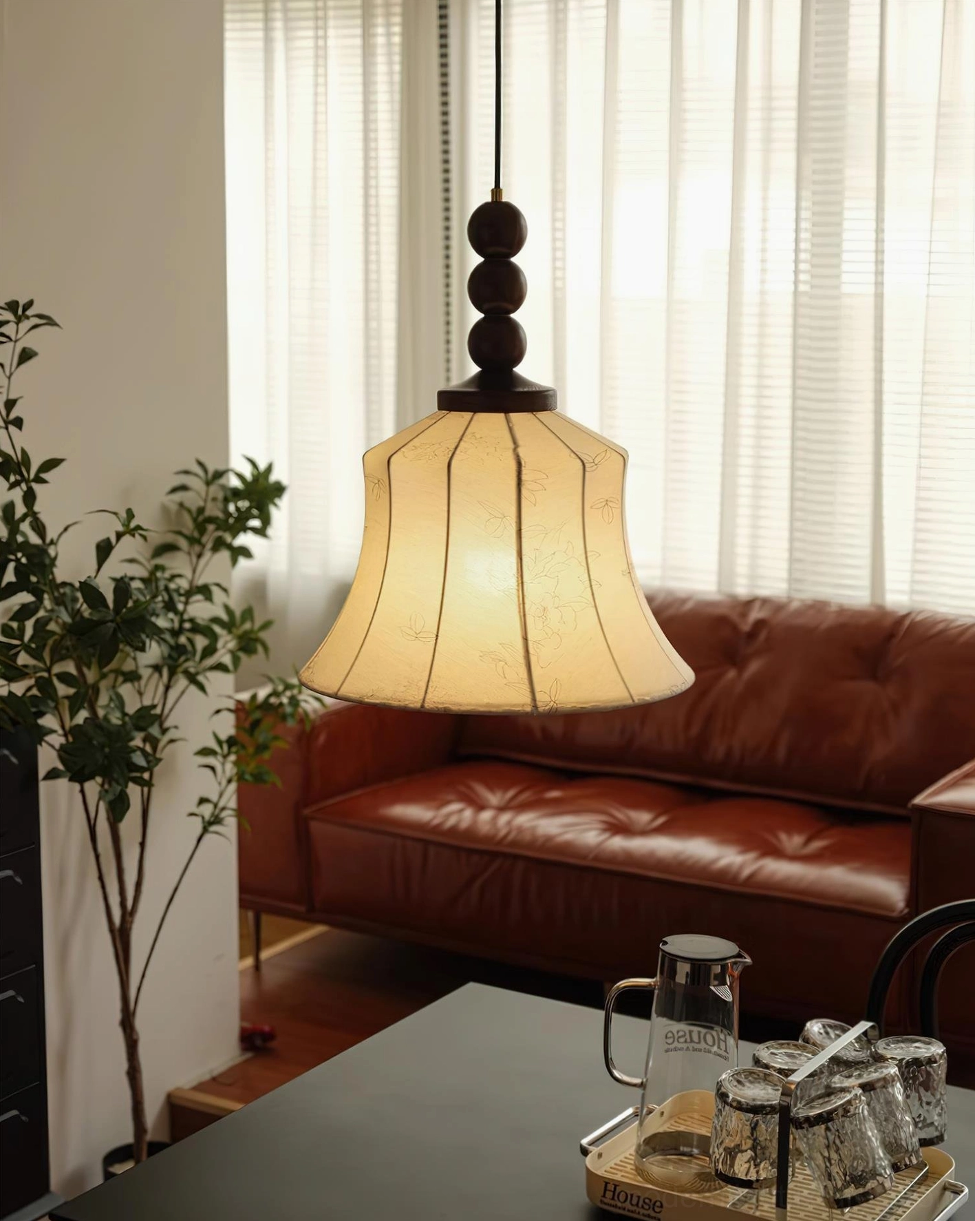 Materia pendant lamp close-up detail showing cream fabric bell shade with dark walnut beaded top fixture