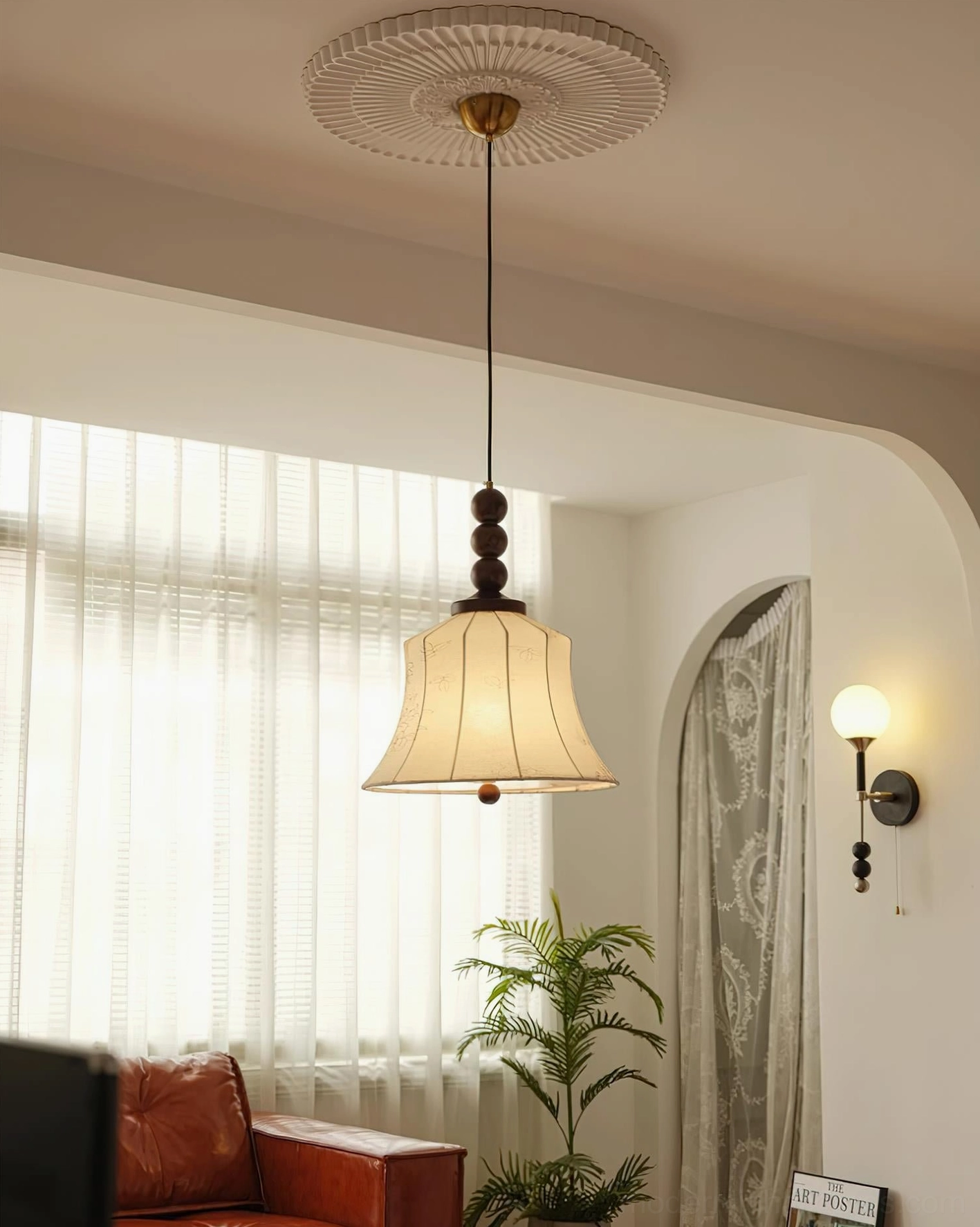 Materia pendant light with cream shade and dark walnut beads above leather sofa in retro living room