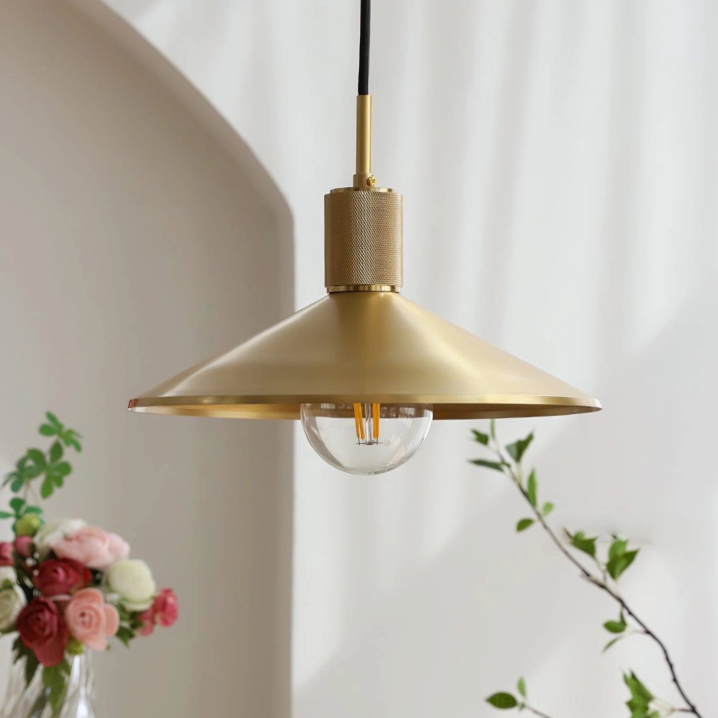 Matte brass conical shade pendant light showing side profile with clear vintage bulb and warm gold metallic finish