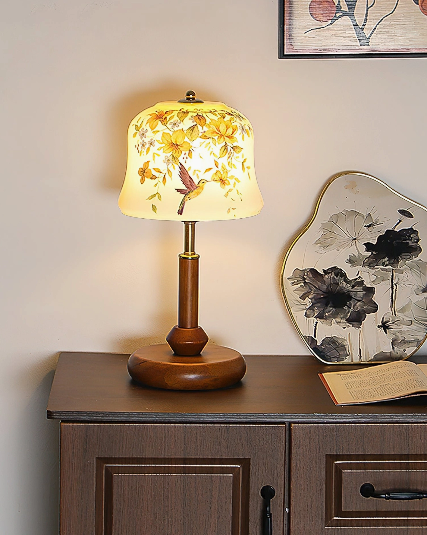 Warm glowing Meadow table lamp on wood furniture with lit floral shade creating cozy ambient lighting atmosphere