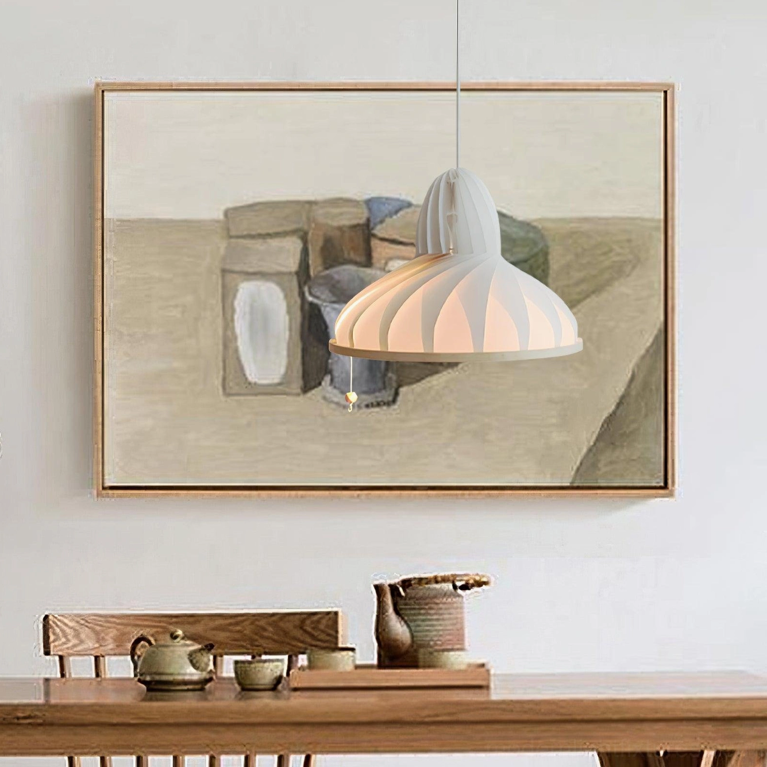 Meblo wave pendant light hanging above wooden dining table in dining room, side perspective with neutral wall art and warm glow