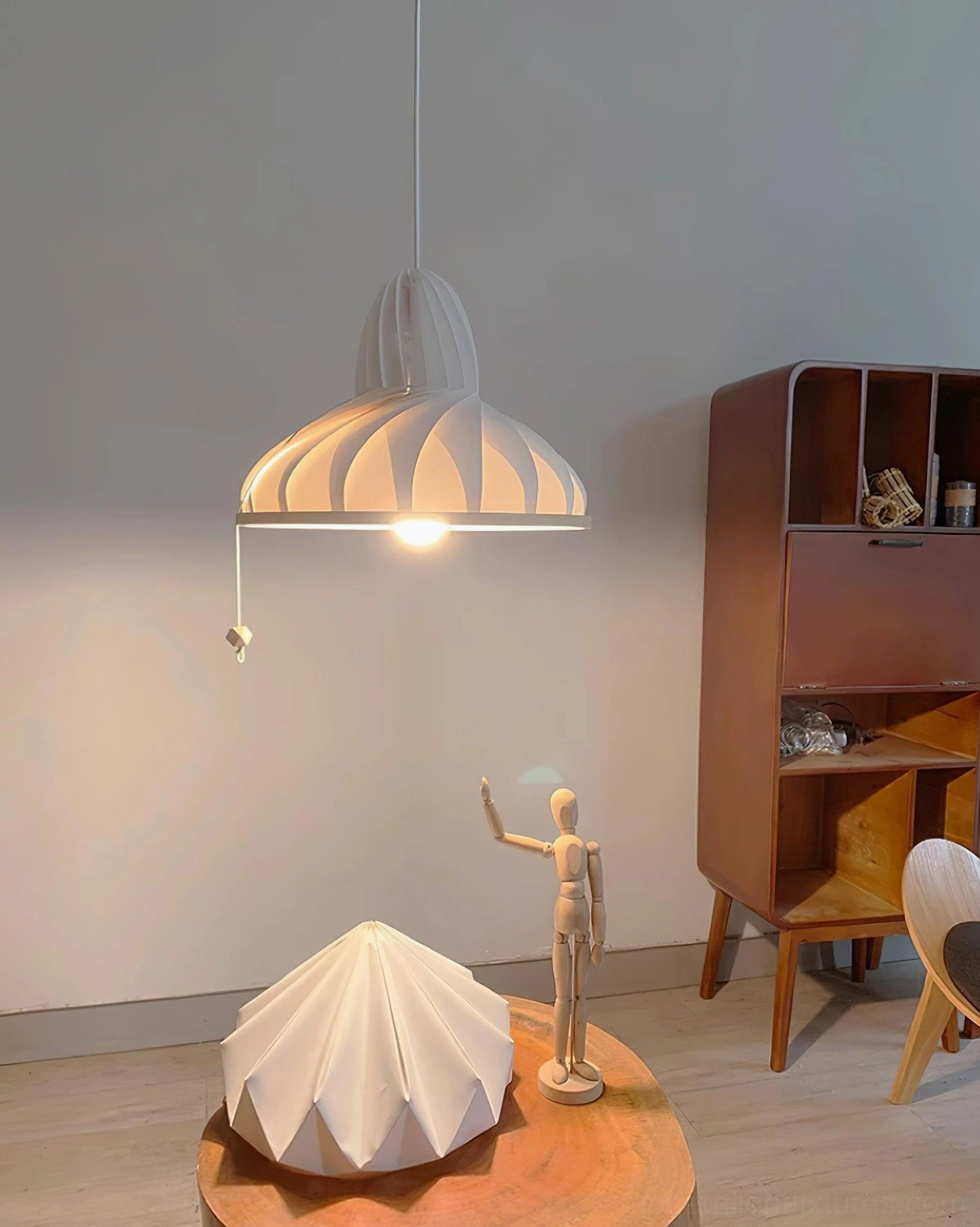 Meblo wave pendant light in home study room paired with wooden cabinet and decorative figurine, warm ambient illumination showing off-white ribbed shade