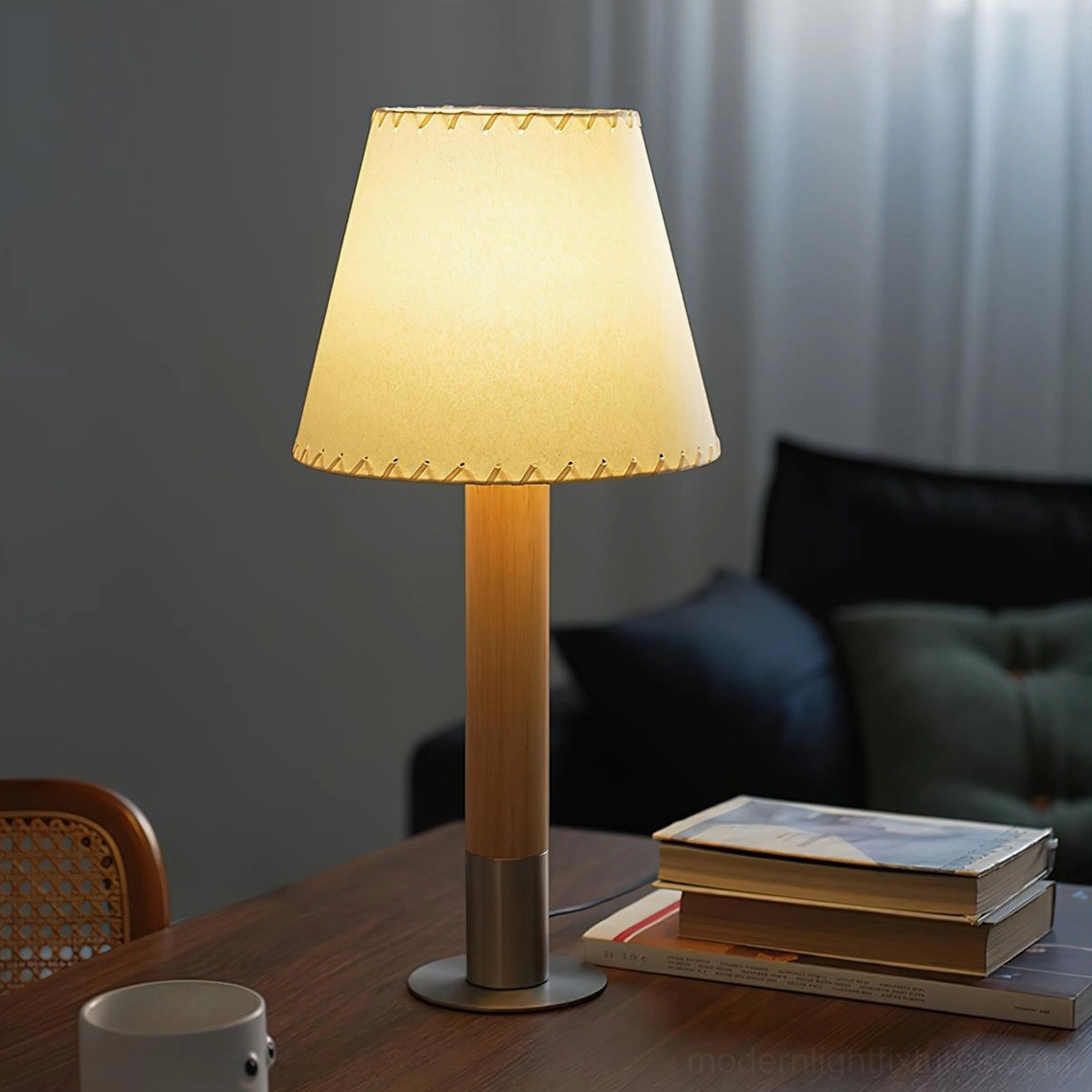 Medium trapezoid table lamp with warm illuminated glow on living room coffee table