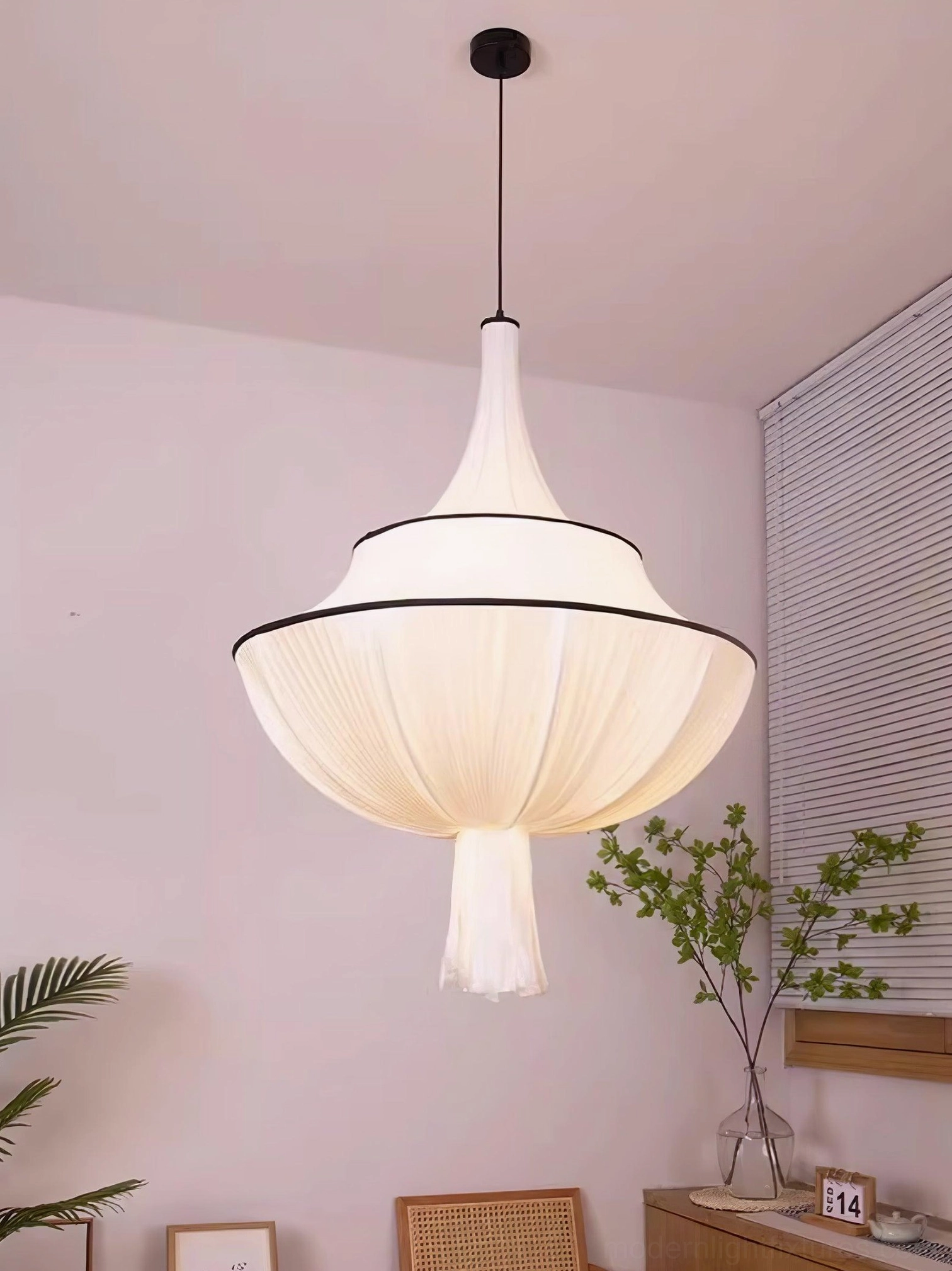 Off-white pleated pendant light with tassel in pink room with louvered window, warm home decor style