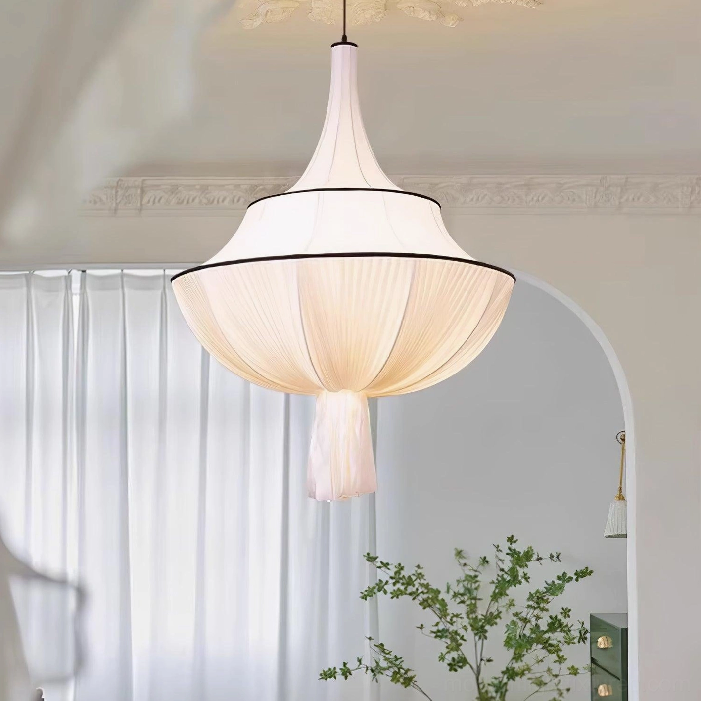 Off-white pleated pendant light with tassel in minimalist boho room with arched doorway and sheer curtains
