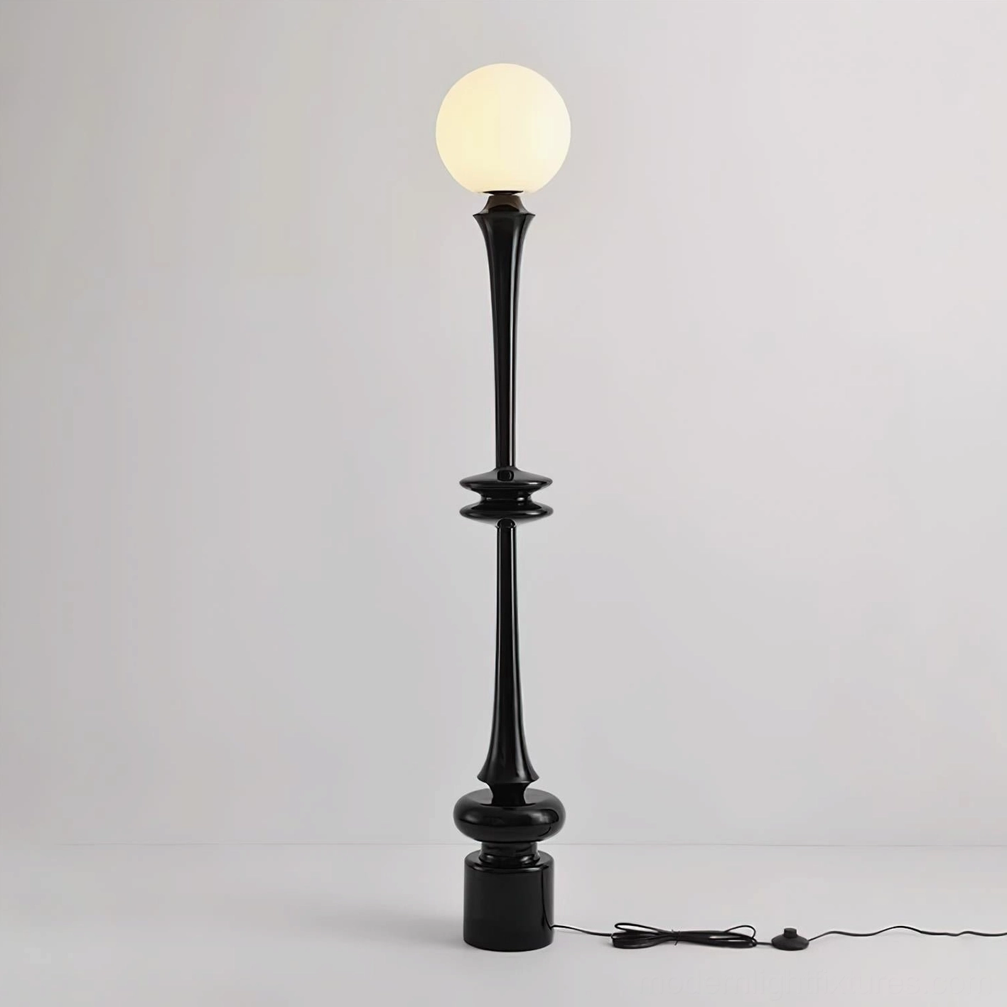 Melrose black floor lamp with frosted glass sphere and black power cable, front studio view