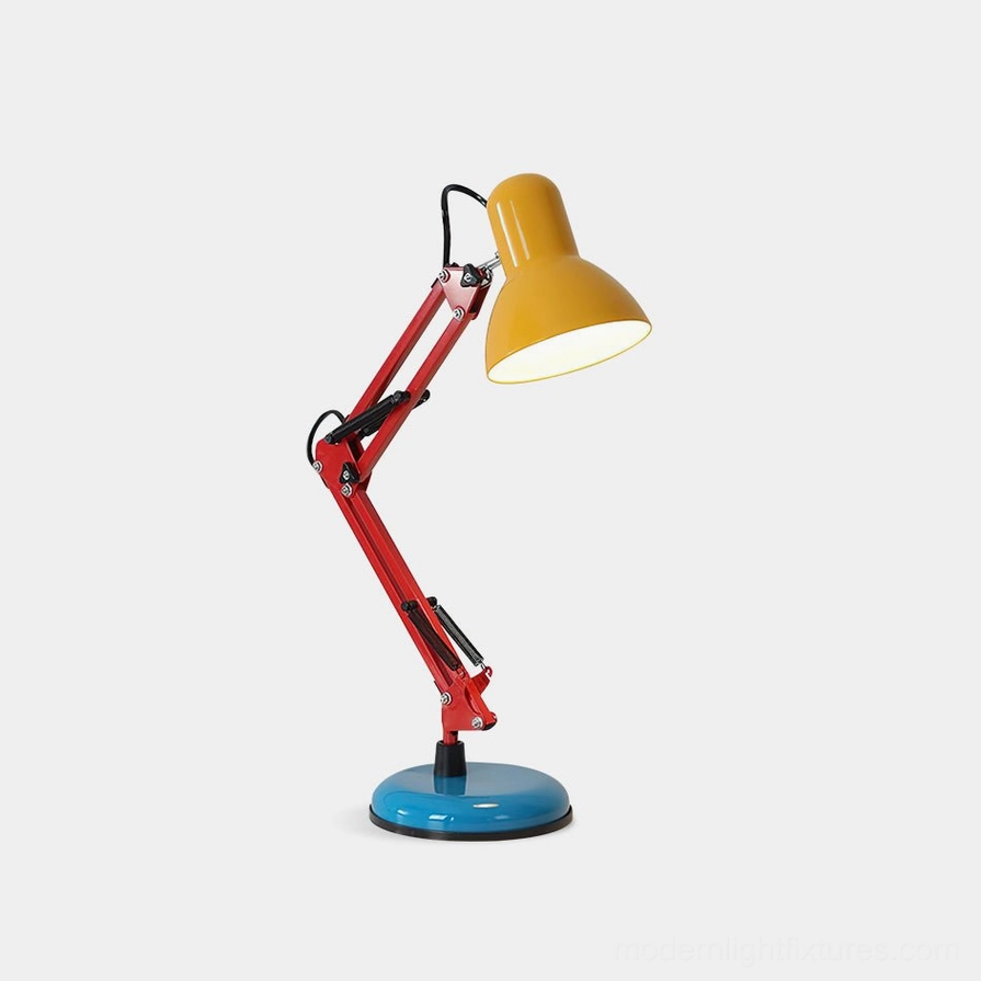 Memphis table lamp with yellow shade, red articulated arm, and cobalt blue round base on white studio background - modern postmodern desk lighting