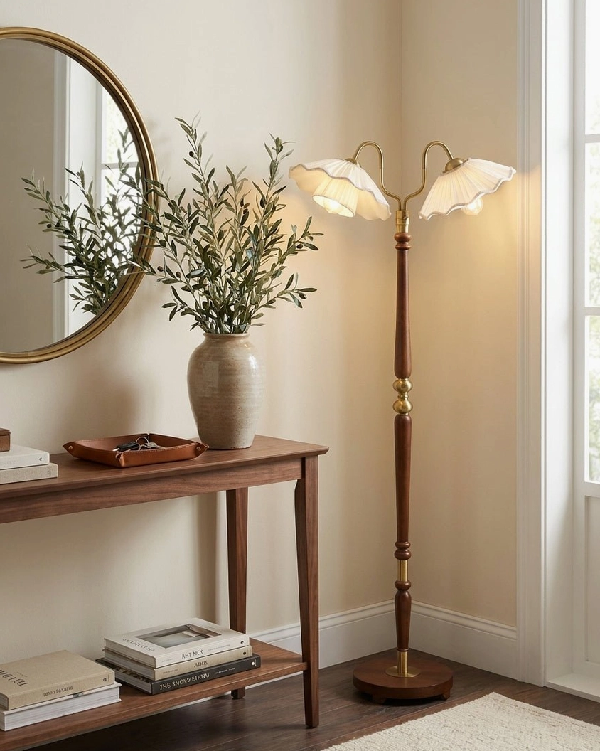 Side profile of Merritt two-light floor lamp in entryway with round mirror and console table, traditional walnut and brass design