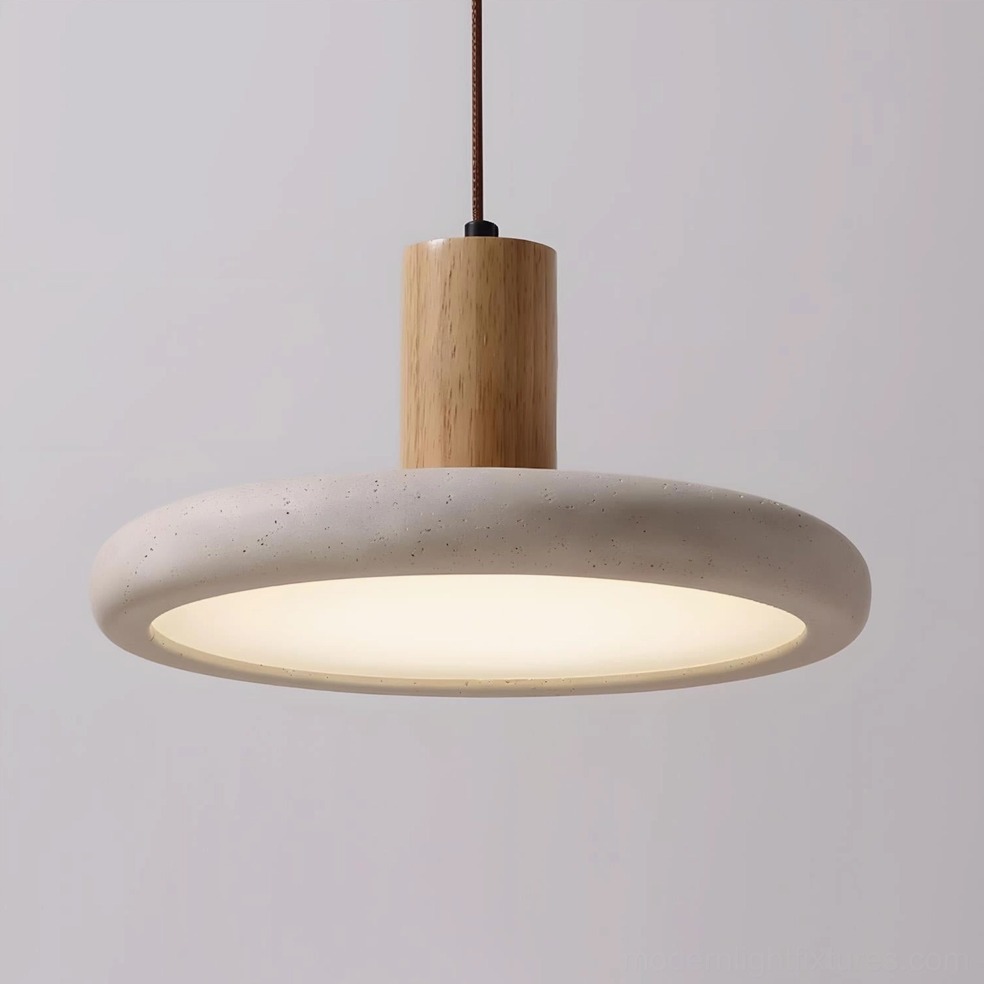 Mesa Halo travertine pendant light bottom-up view isolated on white background revealing rough natural stone texture and warm glowing interior
