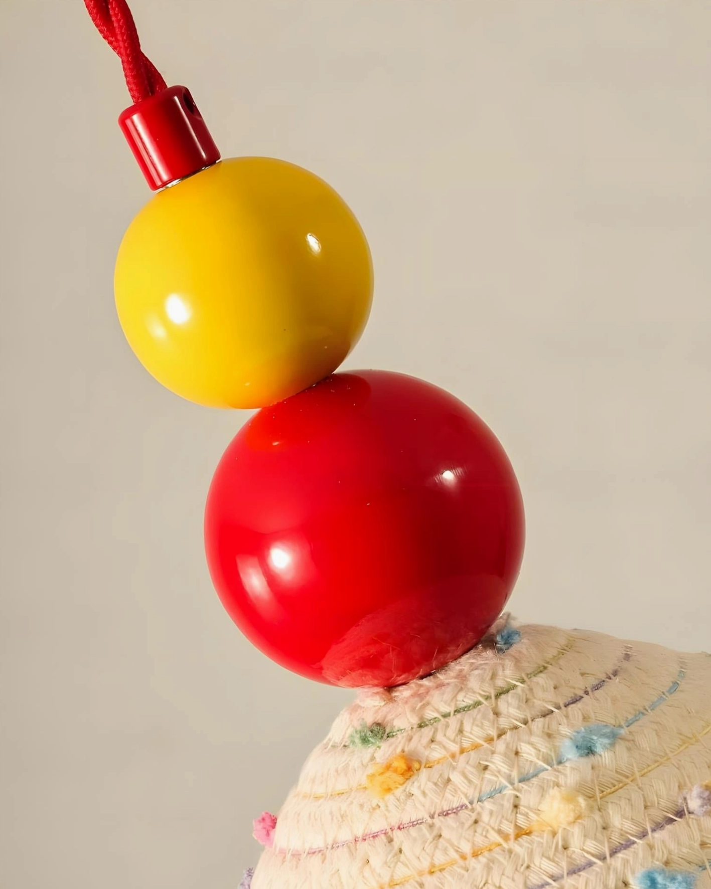 Decorative metal joint close-up showing glossy red and yellow spherical bead elements on wall sconce